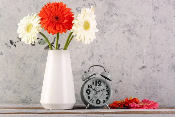 Alarm Clock Vase Beautiful Gerbera Flowers Grey Grunge Background — Stock Photo, Image
