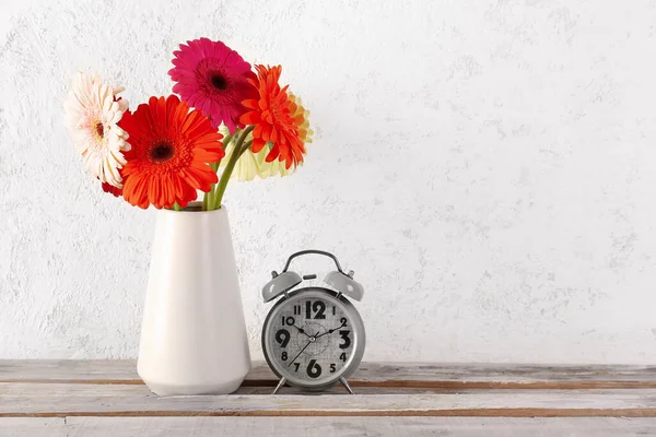 Ξυπνητήρι Και Βάζο Όμορφα Λουλούδια Gerbera Λευκό Φόντο Grunge — Φωτογραφία Αρχείου