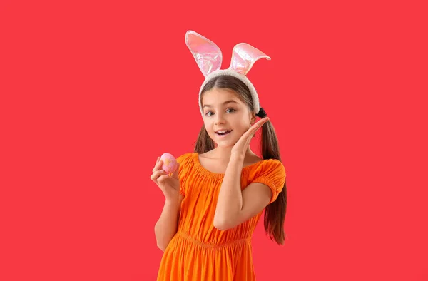 Kırmızı Arka Planda Paskalya Yumurtası Olan Tavşan Kulaklı Küçük Kız — Stok fotoğraf