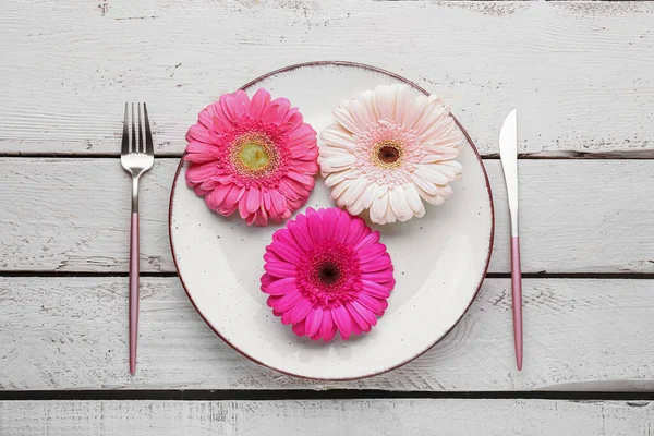 stock image Table setting with beautiful gerbera flowers on white wooden background