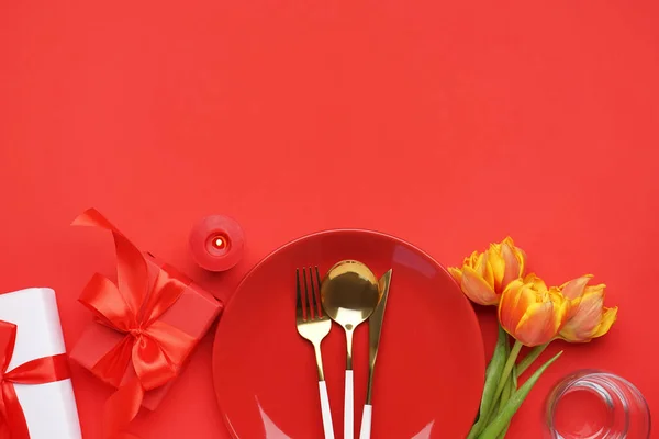 赤い背景に美しいチューリップの花やギフトボックスとテーブルの設定 — ストック写真