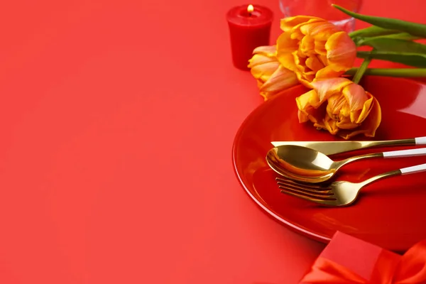 赤い背景に美しいチューリップの花とテーブルの設定 — ストック写真