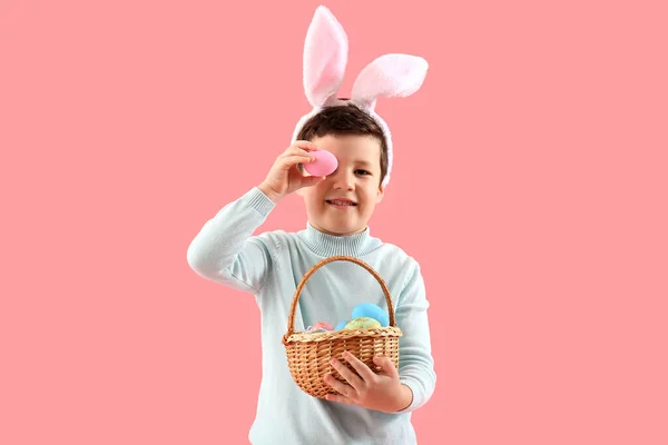 Słodki Chłopczyk Króliczymi Uszami Koszykiem Wielkanocnym Różowym Tle — Zdjęcie stockowe