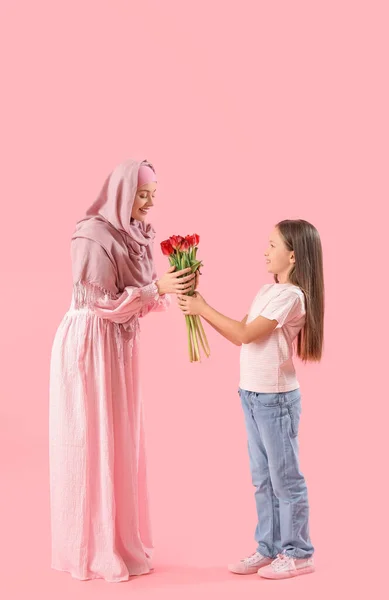 Kleines Mädchen Begrüßt Ihre Muslimische Mutter Mit Tulpen Auf Rosa — Stockfoto