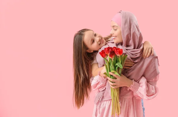 Little Girl Her Muslim Mother Tulips Hugging Pink Background — Stockfoto