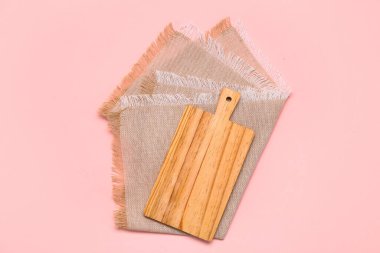 Kesme tahtası ve pembe arka planda temiz peçete