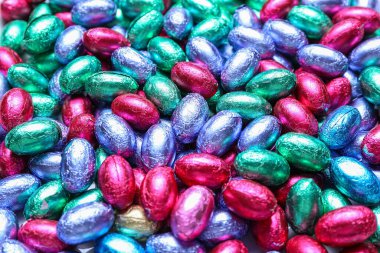 Çikolata yığını Paskalya yumurtaları renkli folyolar, yakın plan.