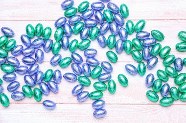 Hafif ahşap arka planda bir yığın çikolata Paskalya yumurtası.