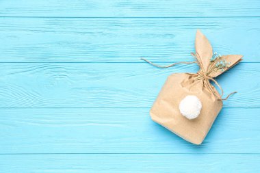 Mavi ahşap arka planda Paskalya tavşanı hediye çantası