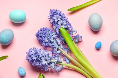 Beautiful hyacinth flowers and Easter eggs on pink background