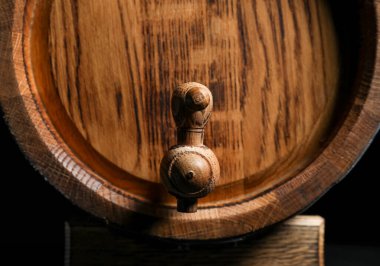 Koyu arkaplanda ahşap varil, yakın plan.