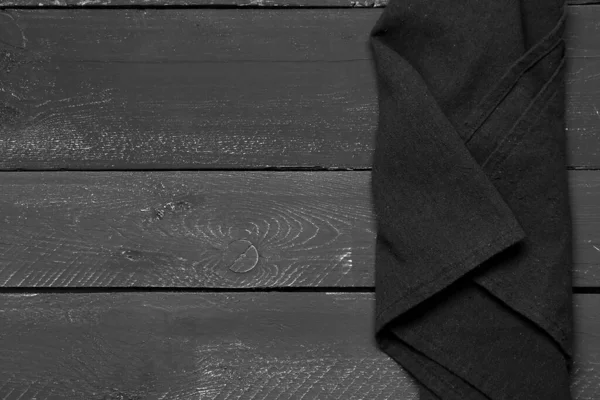 黑色木制背景的折叠式餐巾 — 图库照片