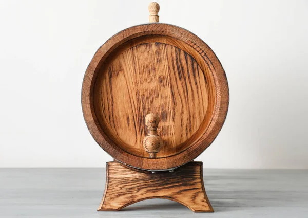 Wooden barrel on table near light wall