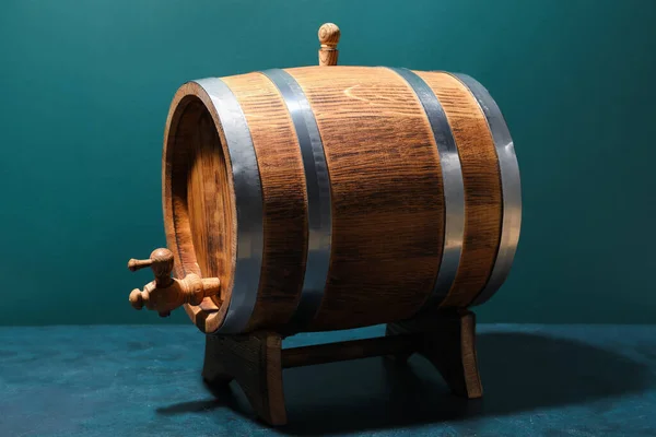 Wooden barrel on table near green wall