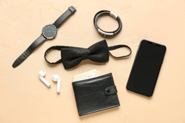 Renkli arka planda cep telefonu ve kulaklıkları olan şık erkek aksesuarları.