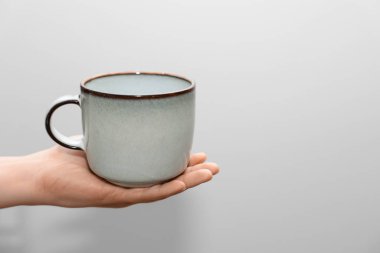 Arka planda bardağı tutan kadın, yakın plan.