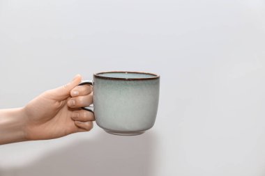 Arka planda bardağı tutan kadın, yakın plan.