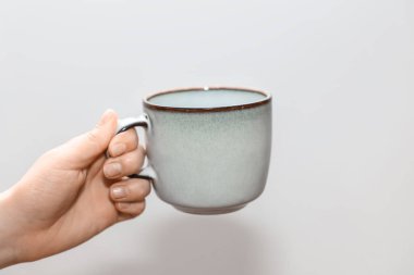 Arka planda bardağı tutan kadın, yakın plan.