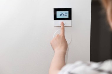 Odanın havalandırmasını ayarlayan kadın, yakın çekim.