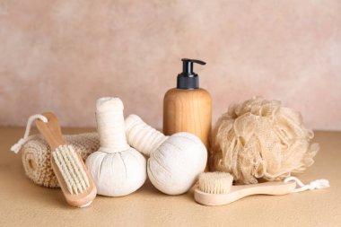 Set of bath supplies and bottle of cosmetic product on color background