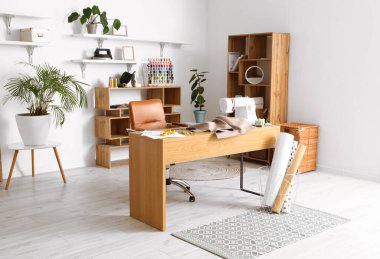 Interior of modern atelier with tailor's workplace and shelving units