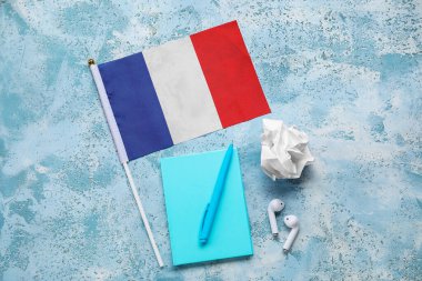 Not defteri, kulaklığı ve grunge arkaplanı üzerine buruşuk kağıt olan Fransa bayrağı.