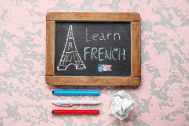 Yazı tahtası LeARN FRENCH, kalemler ve grunge arkaplan üzerine buruşuk kağıt