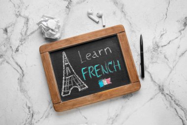 Yazı tahtası LeARN FRENCH, kulaklıklar, grunge arkaplan üzerine buruşuk kağıt