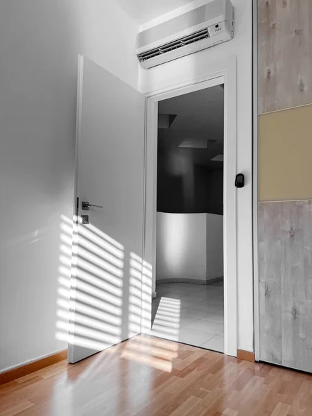 Open white door in light room