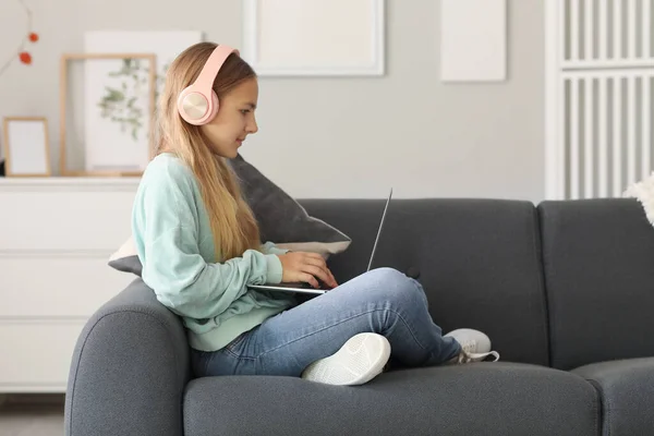 Κοριτσάκι Ακουστικά Που Χρησιμοποιεί Φορητό Υπολογιστή Στον Καναπέ Στο Σπίτι — Φωτογραφία Αρχείου