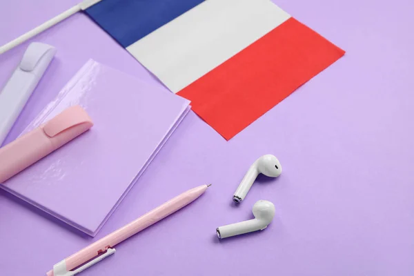 Σημαία Της Γαλλίας Γραφική Ύλη Και Ακουστικά Λιλά Φόντο Closeup — Φωτογραφία Αρχείου