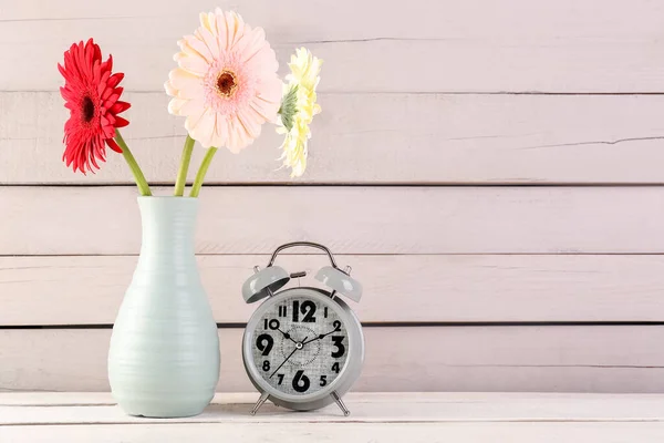 Relógio Despertador Vaso Com Belas Flores Gerbera Fundo Madeira — Fotografia de Stock