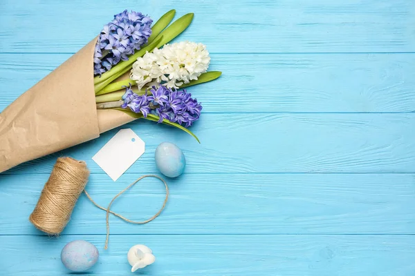 Sümbül çiçekli kompozisyon, mavi ahşap arka planda paskalya yumurtası ve iplik.
