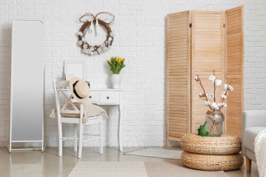 Paskalya çelengi, çiçekler ve işyeriyle oturma odasının içinde.