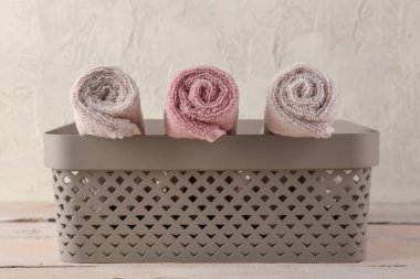 Tahta masanın üzerinde yumuşak havlular olan sepet.