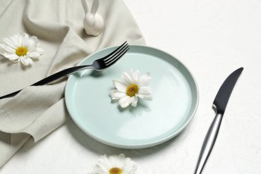 Beyaz arka planda papatya çiçekleri olan Paskalya kutlaması için masa ayarları