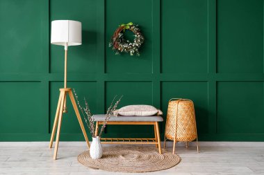 Interior of stylish room with Easter wreath, soft bench and lamps