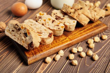 Lezzetli bisküviler ve kahverengi ahşap arka planda fındıklar.