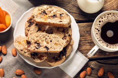 Lezzetli bisküviler ve ahşap arka planda bir fincan kahve.