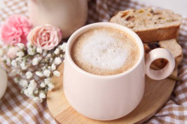 Lezzetli bisküviler ve peçeteli bir fincan kahve.