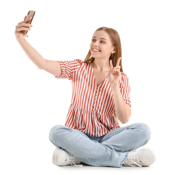 Vacker Flicka Med Mobiltelefon Tar Selfie Vit Bakgrund — Stockfoto