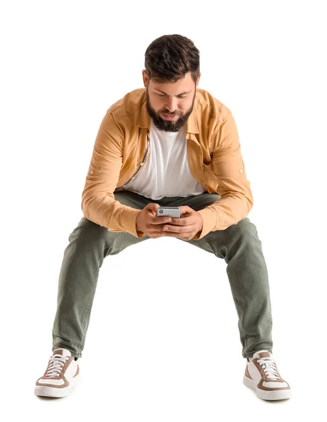 Homem Barbudo Jovem Usando Telefone Celular Cadeira Fundo Branco — Fotografia de Stock
