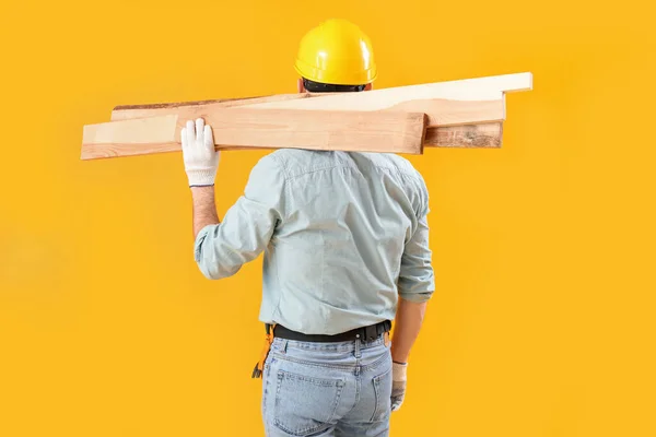 Homem Carpinteiro Com Pranchas Madeira Fundo Amarelo Vista Traseira — Fotografia de Stock