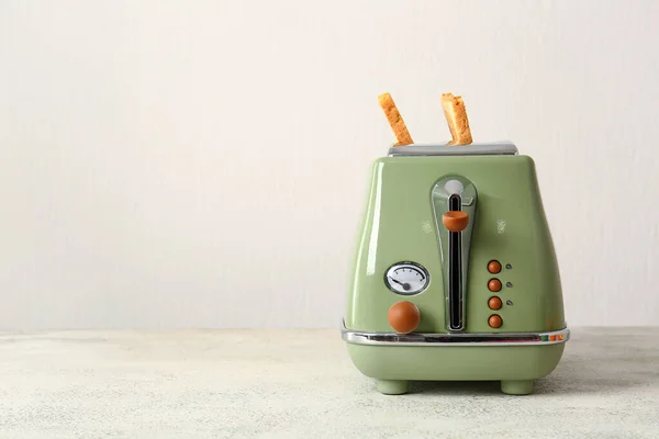 stock image Modern toaster with crispy bread slices on white table