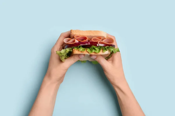 Weibliche Hände Halten Köstliches Schinkensandwich Auf Blauem Hintergrund — Stockfoto