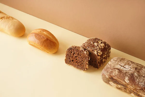 Loaves Different Bread Beige Table Brown Wall — Stock Photo, Image
