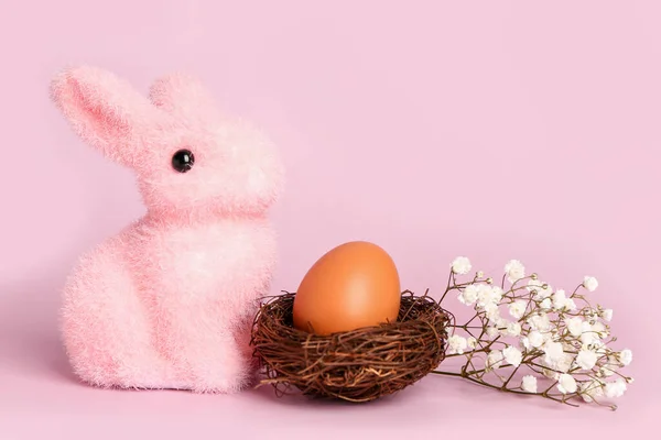 Гнездо Пасхальными Яйцами Игрушечным Кроликом Цыганскими Цветами Розовом Фоне — стоковое фото