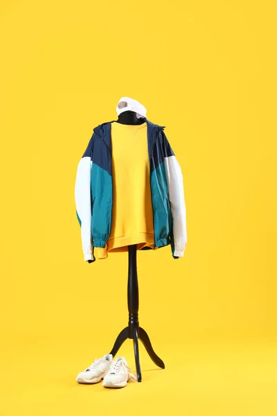 Mannequin with sports clothing on yellow background