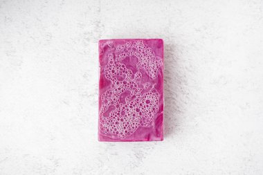 Natural soap bar with foam on light background