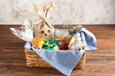 Paskalya tavşanı hediye paketi ve ahşap masada grunge duvarına yapıştırılmış şekerler.